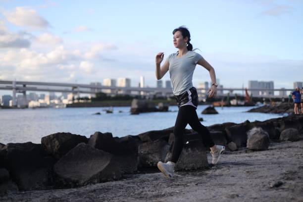istock Young beautiful female running on the beach 1176910573