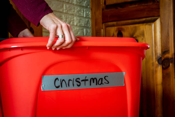 Christmas decorations. Woman opening a storage box full of Christmas decorations for the holiday season. christmas decoration storage stock pictures, royalty-free photos & images