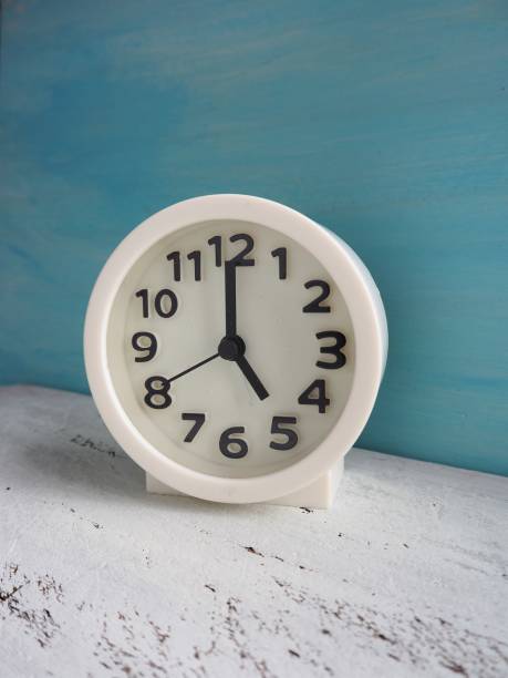 istock White clock pointing to 5 o'clock with white and light blue painted wooden background 1176912676