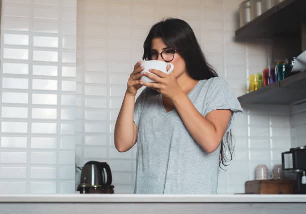 istock young woman drinking coffee at home 1176921889