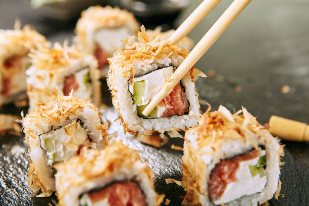 macro shot of eating katsuobushi uramaki sushi rolls in restaurant closeup - susi imagens e fotografias de stock