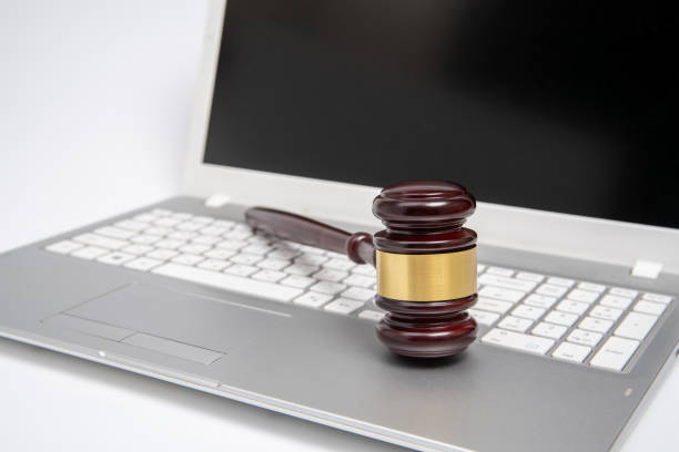 Wooden judge gavel on a silver laptop computer, cyber law or online auction concept. Wooden judge gavel on a silver laptop computer, cyber law or online auction concept. gavel keyboard stock pictures, royalty-free photos & images