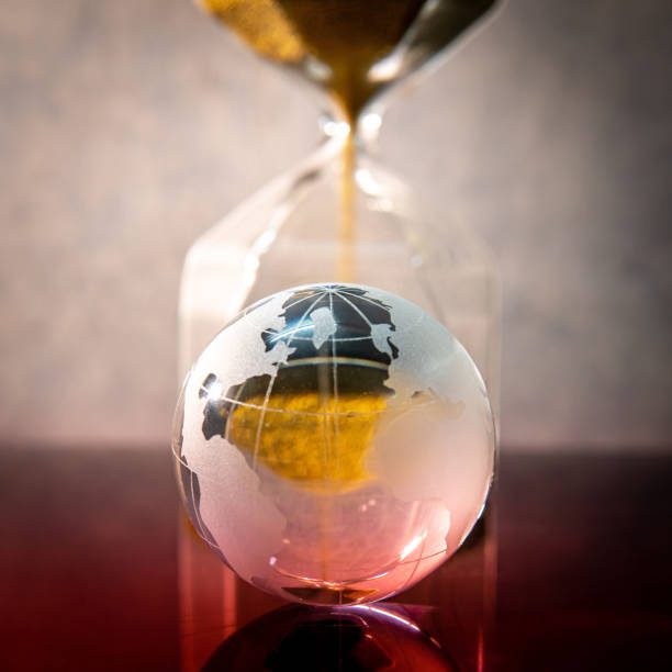 istock Hourglass and world globe crystal on the table 1176932109