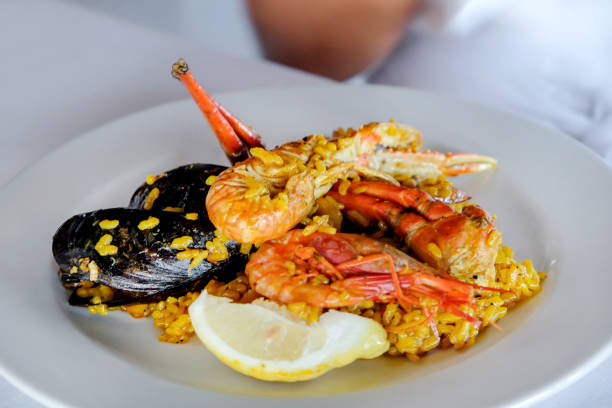 mangiare autentica paella di pesce - seafood lobster paella prepared shellfish foto e immagini stock