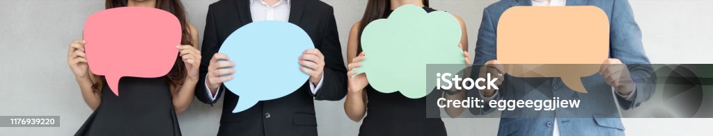 People are holding colorful Speech Bubbles. Group of Business People holding blank colorful Speech Bubbles. Banners, Panoramic, Web. Questionnaire Stock Photo