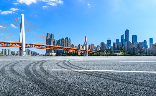 Empty asphalt road and Chongqing architectural landscape with bridge,China