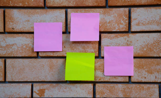pink and green note pad on the brick wall