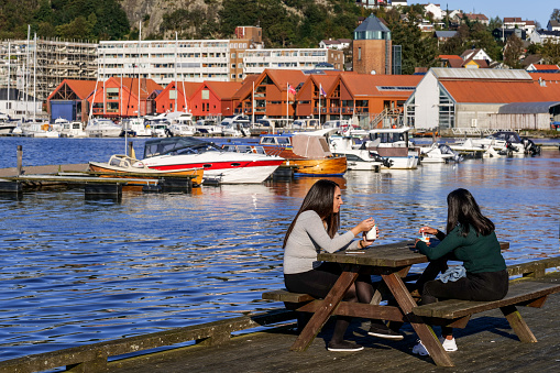 Sandnes, Norway, September 22 - Two people enjoy a drink in the promenade of the Sandnes harbor. The town of Sandnes is located at the southern end of the Gandsfjord, 15 kilometers south of the city of Stavanger in southern Norway. Photo in HD format