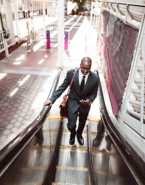 istock businessman walking on the escalator 1176946058