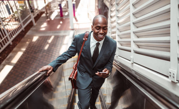 istock businessman walking on the escalator 1176946100