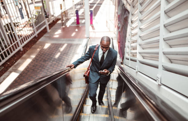 istock businessman walking on the escalator 1176946175
