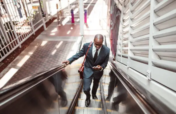 Photo of businessman walking on the escalator