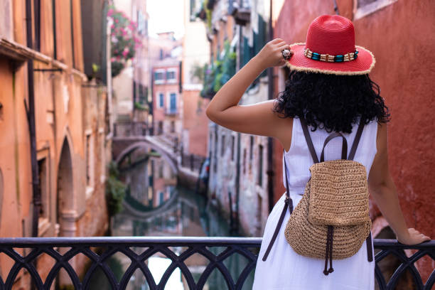 赤い帽子をかぶった観光客の女性がヴェネツィア運河を見ています。 - plaza de espana barcelona street catalonia ストックフォトと画像