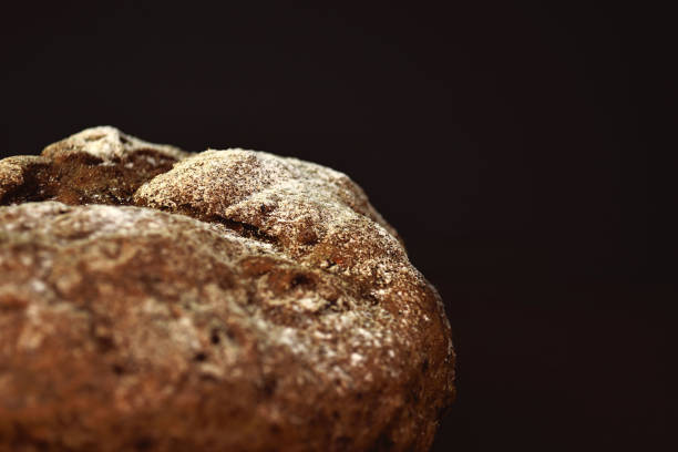 istock Whole grain rye bread, isolated on dark background. Closeup 1176949213