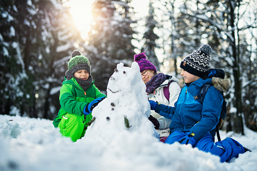 Kids building a snowman on a winter day