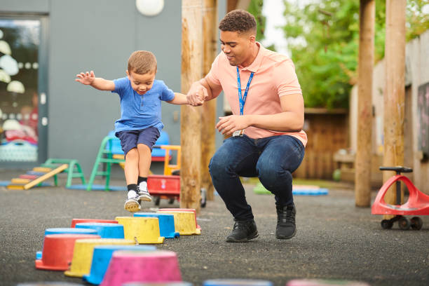 istock nursery worker with child in playground 1176953751