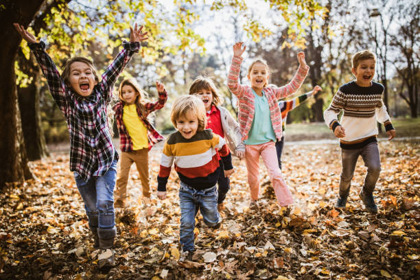istock Playful kids having fun while running and screaming in autumn day. 1176955901