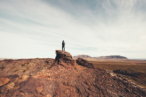 Man standing on the rock on top of Eldborg crater in Iceland.