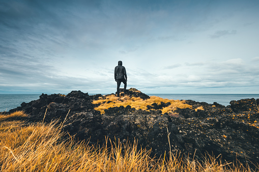 Man standing on colorful volcanic coast in Iceland.