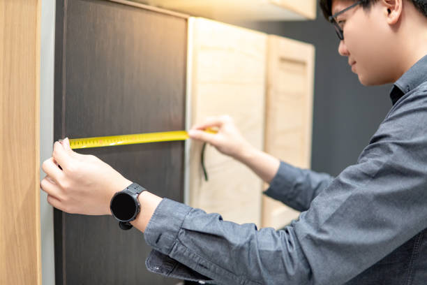 istock Asian man using tape measure on cabinet materials 1176959090