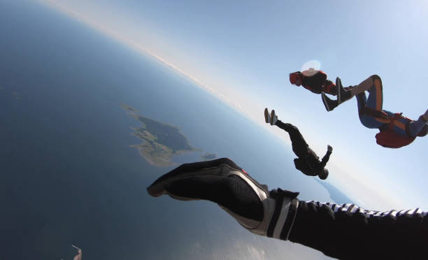 istock Skydivers fall through clear skies, aerial flight 1176964303