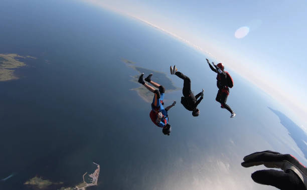 istock Skydivers fall through clear skies, aerial flight 1176964316