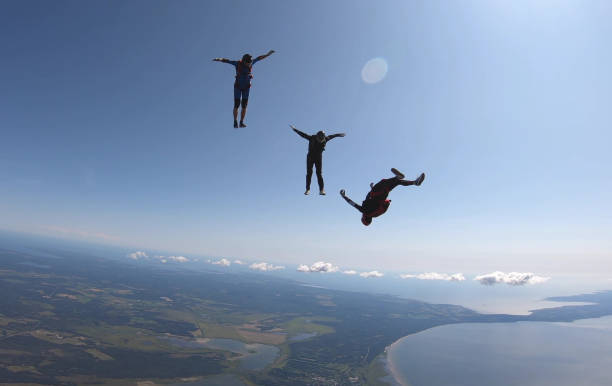 istock Skydivers fall through clear skies, aerial flight 1176964374