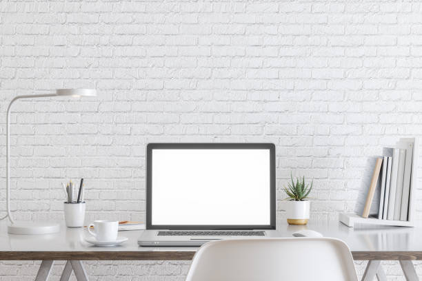 istock Laptop with blank white screen, and office supplies on a desk 1176965499