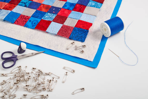 assembling of a quilt sandwich, curved basting pins and sewing accessories - quilt textile patchwork thread imagens e fotografias de stock