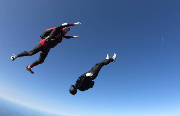 istock Skydivers fall through clear skies, aerial flight 1176966270