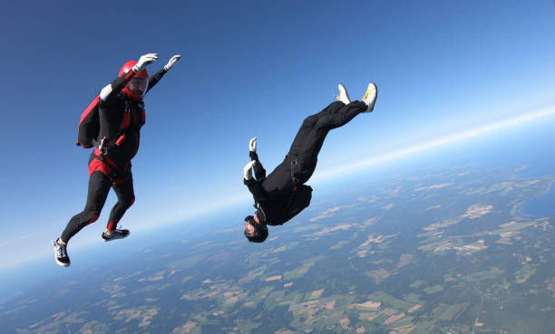 istock Skydivers fall through clear skies, aerial flight 1176966333