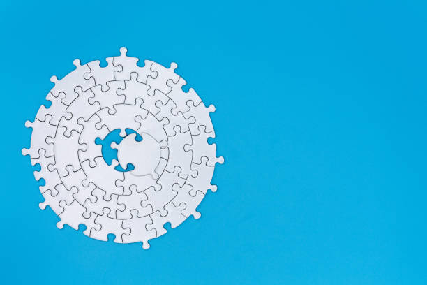 istock White jigsaw pieces on a blue background, Copy space, Jigsaw puzzle with missing piece. Completing final task. 1176966593