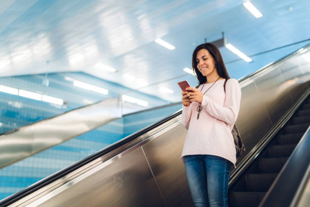 istock Using phone on an escalator to metro station 1176969532