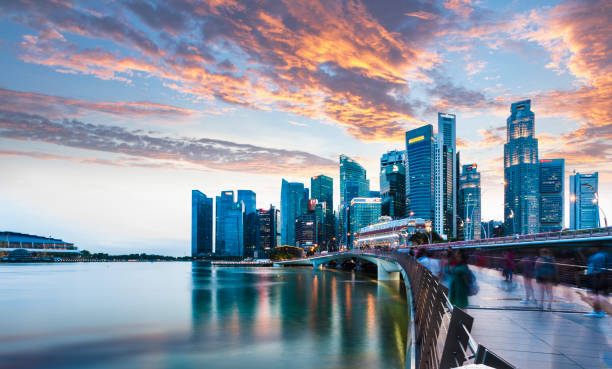 Singapore Skyline at Marina Bay at Twilight with glowing sunset illuminating the clouds stock photo