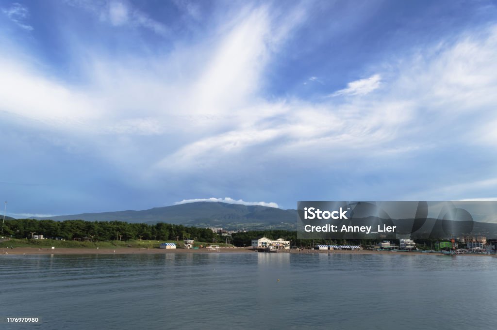 Majestic cloudscape over hallasan mountain and Jeju island with view on  iho tewoo beach Adventure Stock Photo