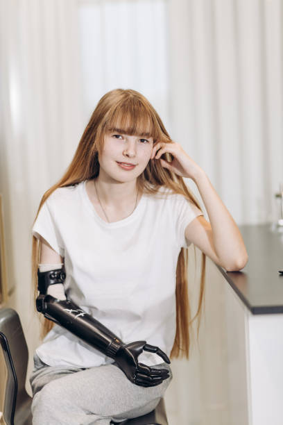 nice girl witout an arm posing to the camera nice girl witout an arm posing to the camera, close up photo.student having a rest at the table witout stock pictures, royalty-free photos & images