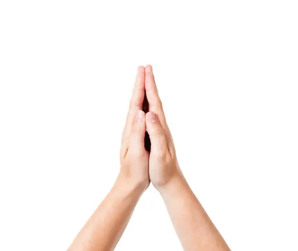 A woman's folded hands are held up, palms together in prayer or submission.