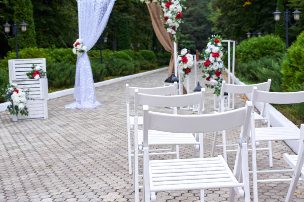 istock Outdoor wedding decorations, arch decorated with red and white flowers, chairs, lanterns. 1176972821