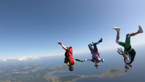 istock Skydivers fall through clear skies, aerial flight 1176974100