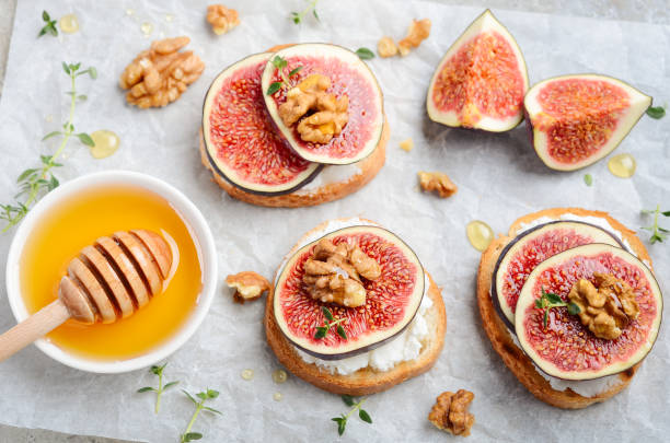 istock Bruschetta with fresh ricotta cheese, figs, nuts, thyme and honey on gray concrete background. 1176974140