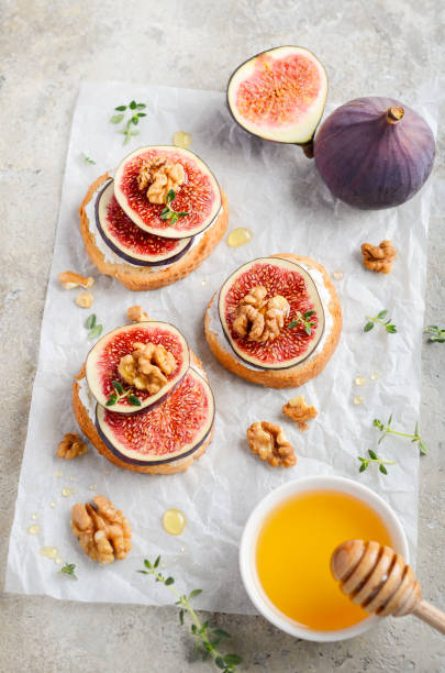 istock Bruschetta with fresh ricotta cheese, figs, nuts, thyme and honey on gray concrete background. 1176974142