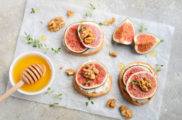 istock Bruschetta with fresh ricotta cheese, figs, nuts, thyme and honey on gray concrete background. 1176974146