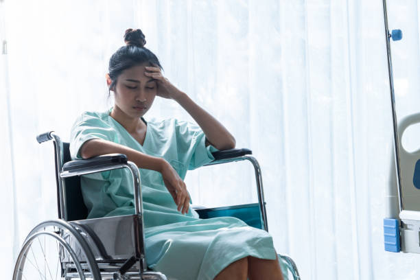 Serious patient sitting on wheelchair in hospital. stock photo