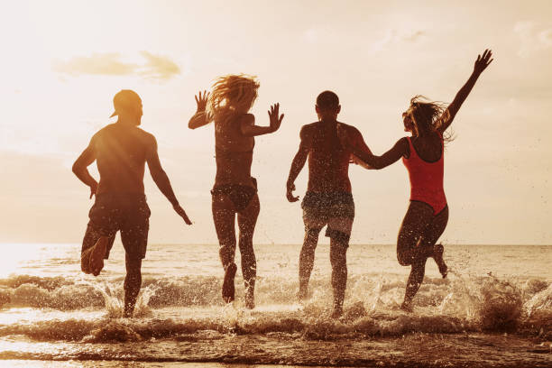 istock Beach party friends runs to the sea 1176976087