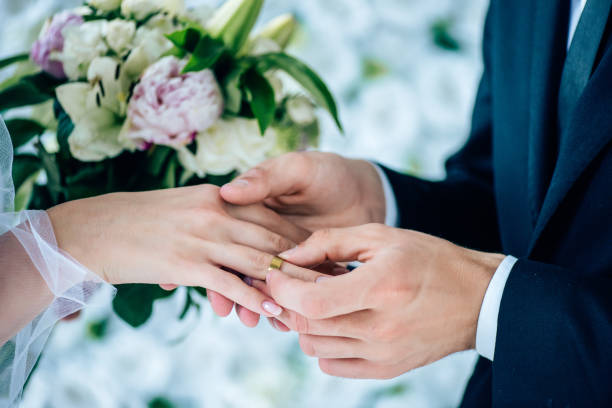 istock cropped view of bridegroom putting wedding ring on finger 1176977198