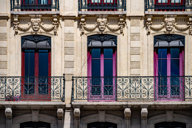 Apartment building exterior in Lyon with wrought iron Juliette balconies in two storeys of upstairs apartments.