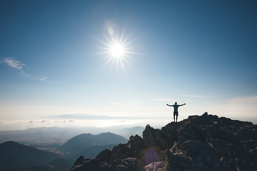 Man standing on the top of Mount Zas, which is the highest point in the Cyclades (Naxos island, Greece).