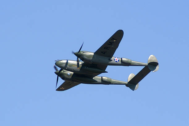 istock WWII fighter airplane P38 Lightning flying in clear blue sky 117697894