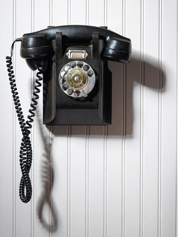 Vintage black telephone  on a white bachground. Telecom technology conept