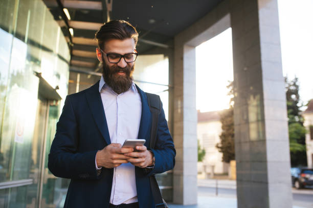 istock Young businessman typing text message on mobile phone outdoors 1176979125